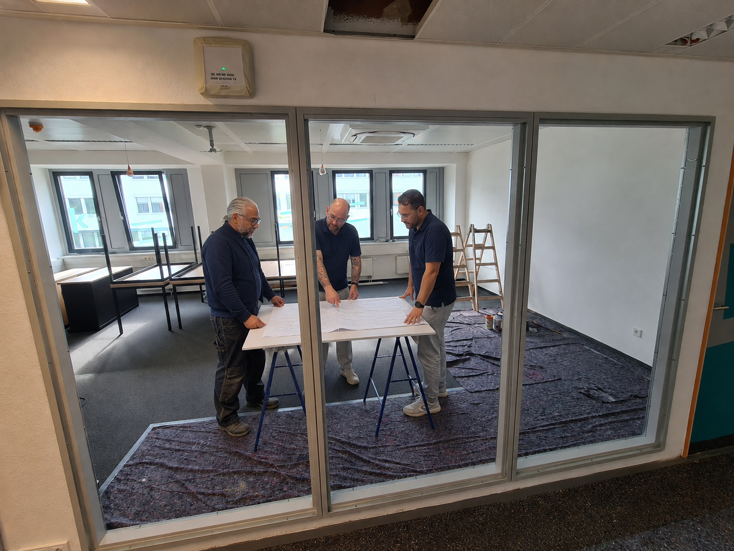Projektbesprechung des IMPULS-Teams auf einer laufenden Innenausbau-Baustelle